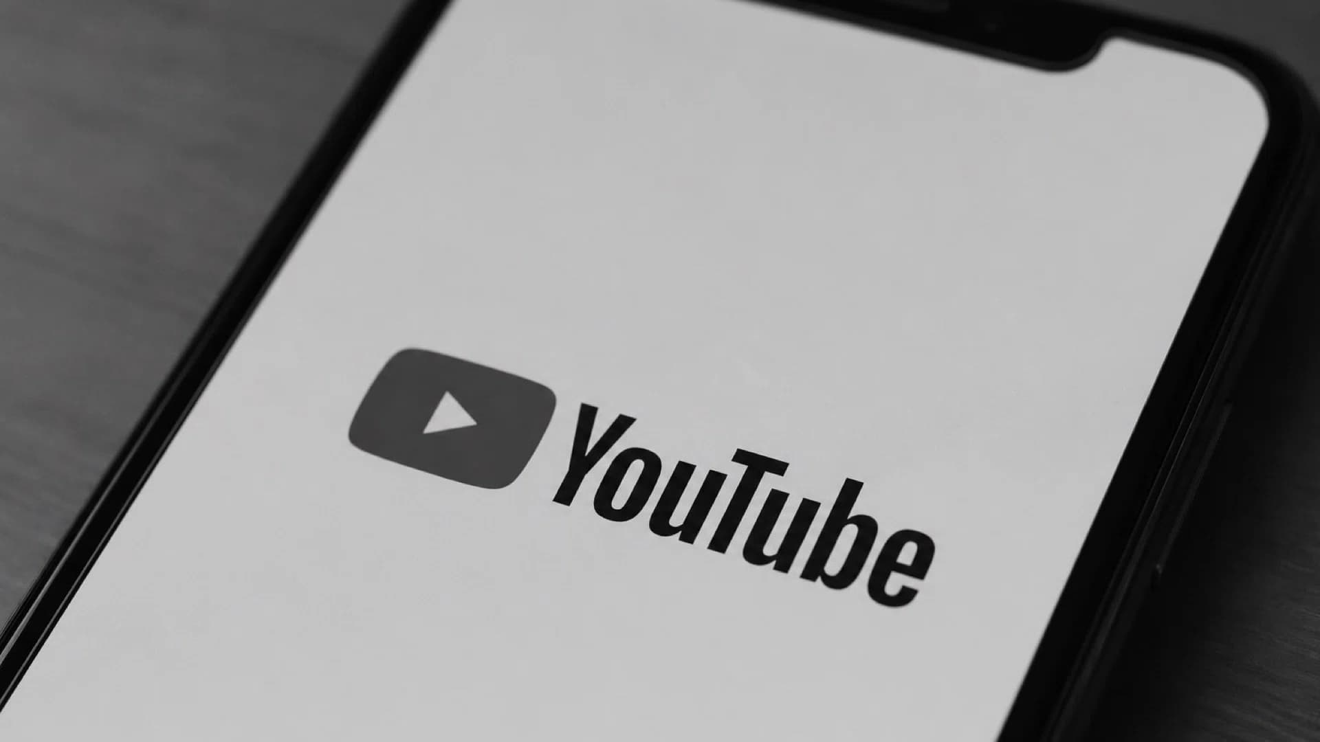 スマートフォンの画面に映るYouTubeのロゴのモノクロ写真
